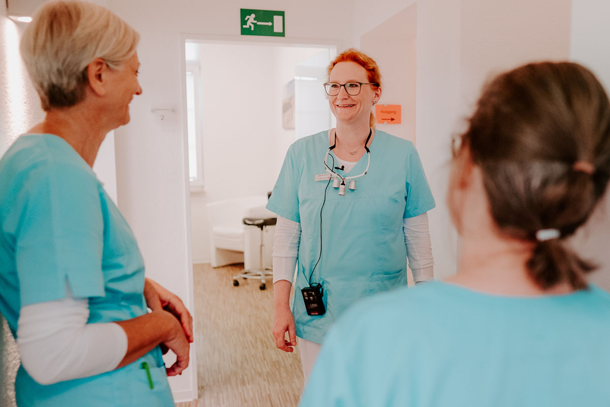 Claudia Zimmer-Mildner, Zahnärztin in Einbeck, unterhält sich mit zwei Mitarbeiterinnen