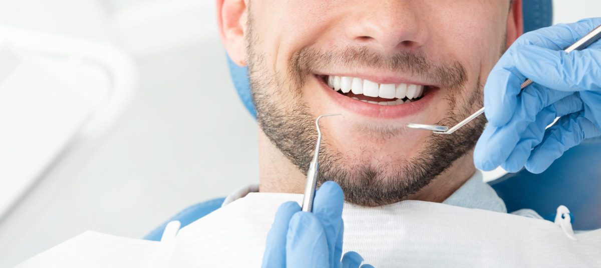 Männlicher Patient bei einer ästhetischen Zahnbehandlung in der Zahnarztpraxis